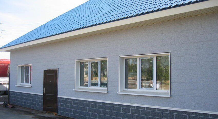 Kombination einer VinyStone Fassade in der Farbe granit (hell) und basalt (Sockel).