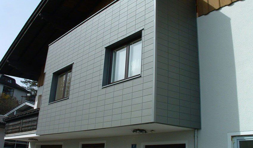 Kombination aus einer klassischen Putzfassade und einer anthrazitfarbene Tonstrukturfassade.