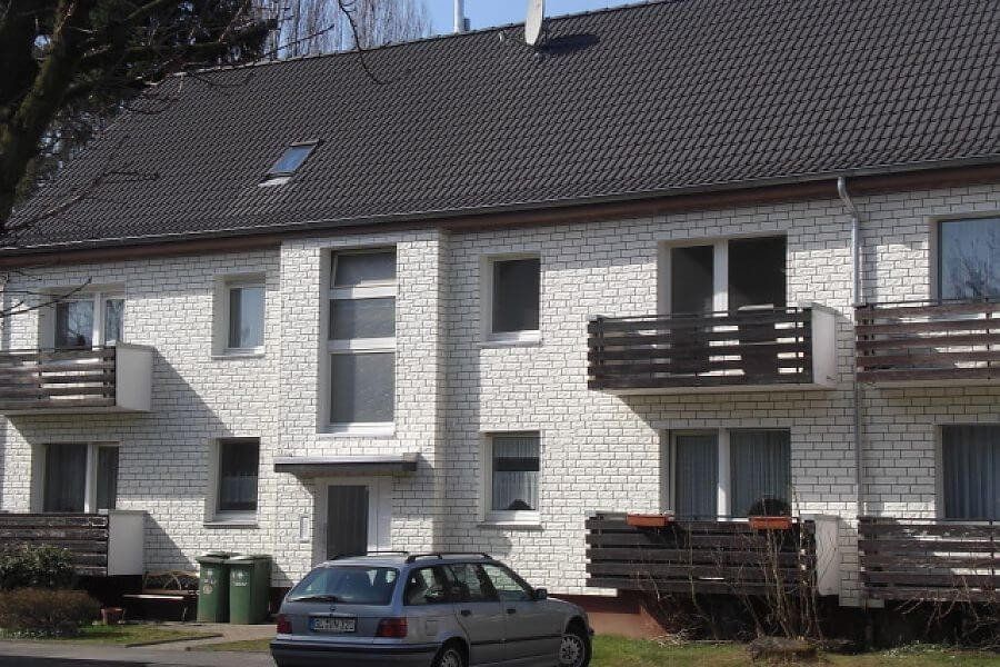 Mehrfamilienhaus mit einer Zierer Fassadenbekleidung in Bruchsteinoptik; Farbe: weiß.