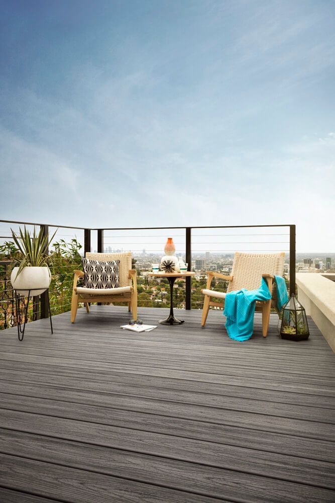 Sitzkombination auf einer eleganten Dachterrasse mit schwarzem Geländer.